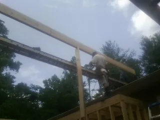 Carpenter setting a ridge beam over a new addition frame — Ice Dam Removal by Roofing Brothers in Roselle Park