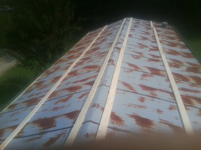 Rusted metal roof panels with new wood purlins before replacement — Storm Damage Roof Repair in Roselle Park by Roofing Brothers