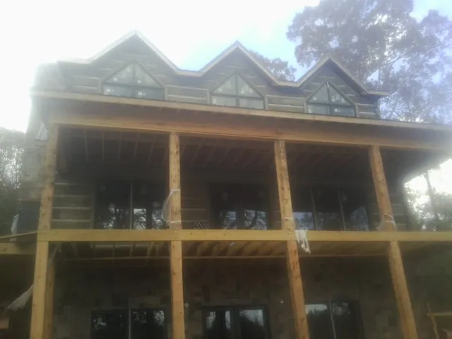 Dormers and porch framing on a large log home under construction — Roof Coating work by our crew in Roselle Park