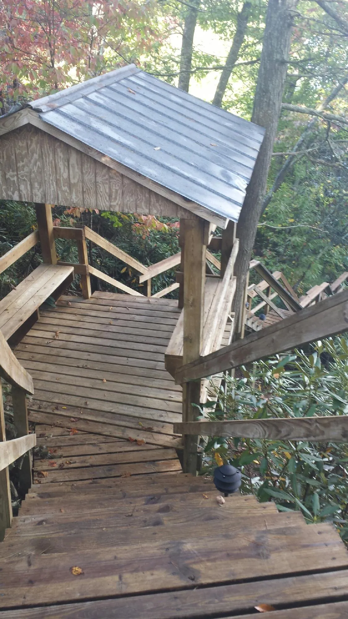 Metal roofed shelter over wooden steps on a wooded walkway — Skylight Repair & Installation work by our crew in Roselle Park