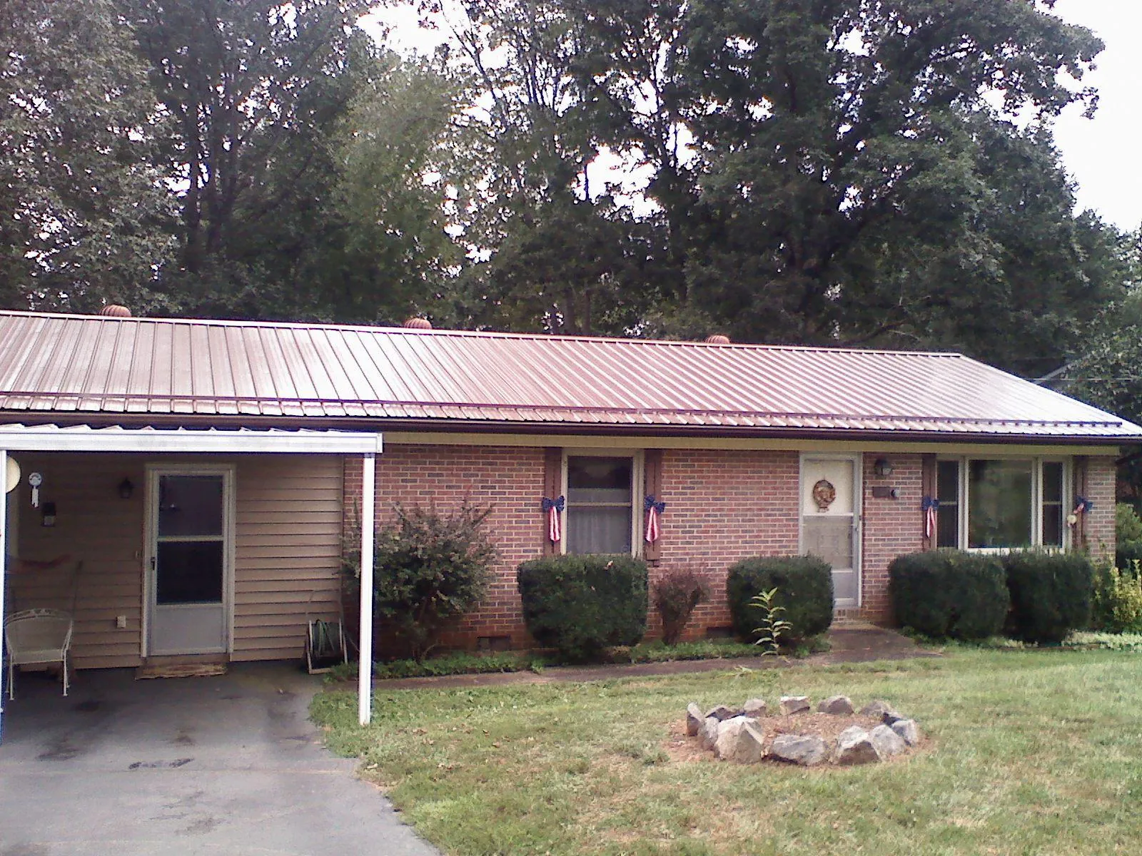 Bronze metal roof and carport on a brick ranch home — Roof Repair work by our crew in Roselle Park